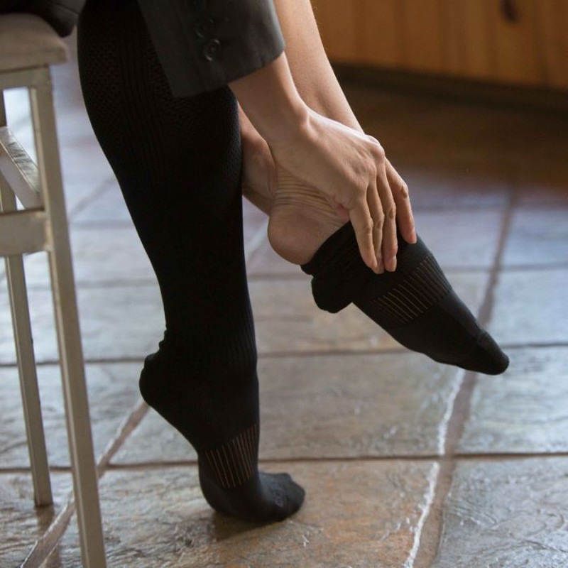 Woman Putting on the Copper Fit Compression Sock